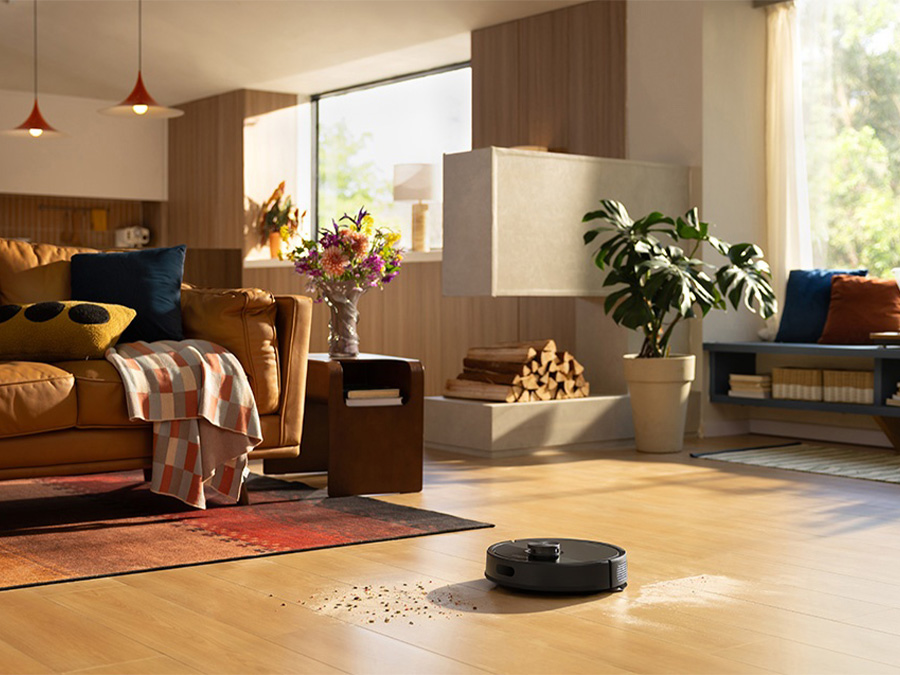 Roborock Q7 TF Schwarz saugt verstreute Verschmutzungen auf dem Boden in einem geräumigen, stilvollen Wohnzimmer