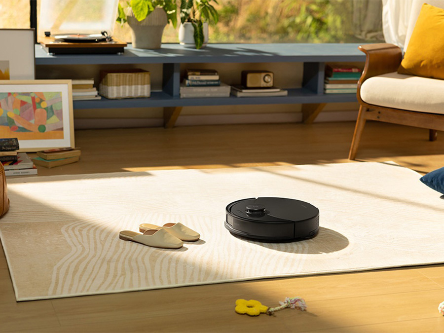 Saugroboter Roborock Q10 PF Black reinigt einen hellen Teppich im Wohnzimmer