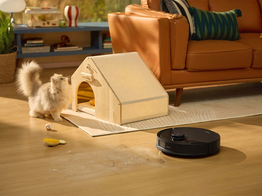 Saugroboter Roborock Q10 PF Black entfernt Tierhaare in der Nähe einer Katze und eines Körbchens