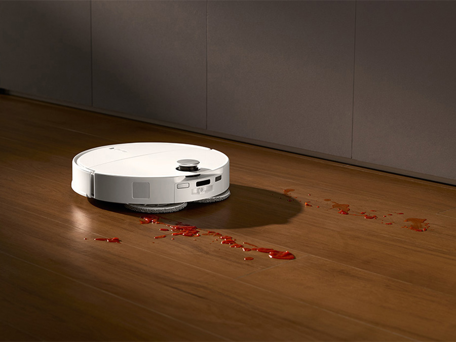 Saugroboter Roborock Qrevo Edge T Weiß wischt einen Holzboden und entfernt verschüttete rote Flüssigkeit