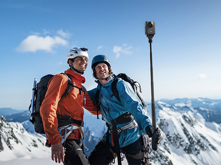 Skifahrer mit DJI Osmo 360 Kamera auf Helm bei dynamischem Abfahrt auf sonnigem Tag