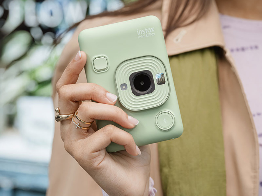 Grüne Fujifilm Instax Mini LiPlay Kamera in Frauenhand, im stilvollen Look