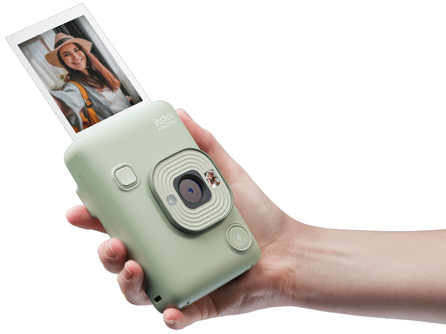 Grüne Fujifilm Instax Mini LiPlay Kamera, die ein Foto von einer Frau im Hut druckt