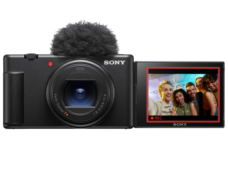 Sony ZV-1 II Kamera mit angeschlossenem Mikrofon und klappbarem Bildschirm, der eine Gruppe beim Filmen zeigt